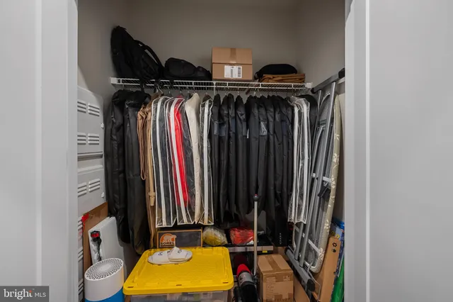 a view of walk in closet with clothes and shoes