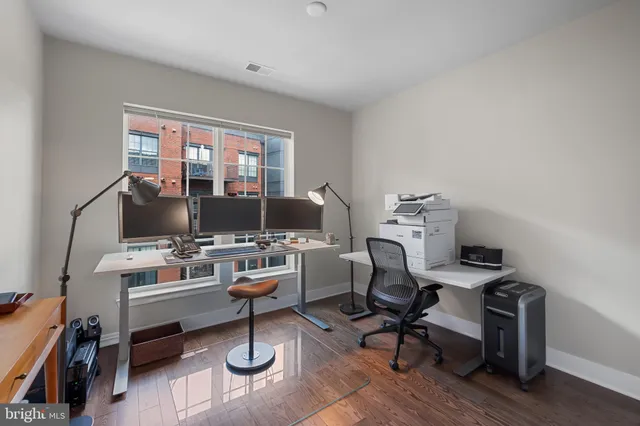 a view of a workspace with furniture and a window