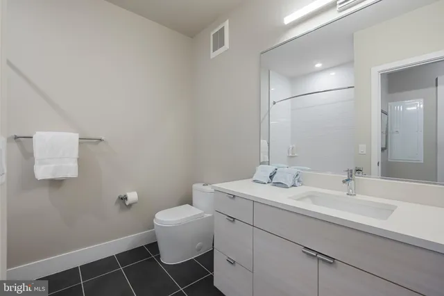 a bathroom with a sink toilet and a mirror