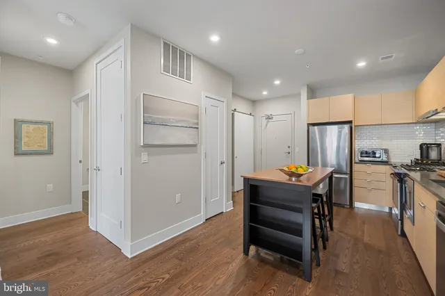 a kitchen with stainless steel appliances kitchen island granite countertop a refrigerator and a stove top oven