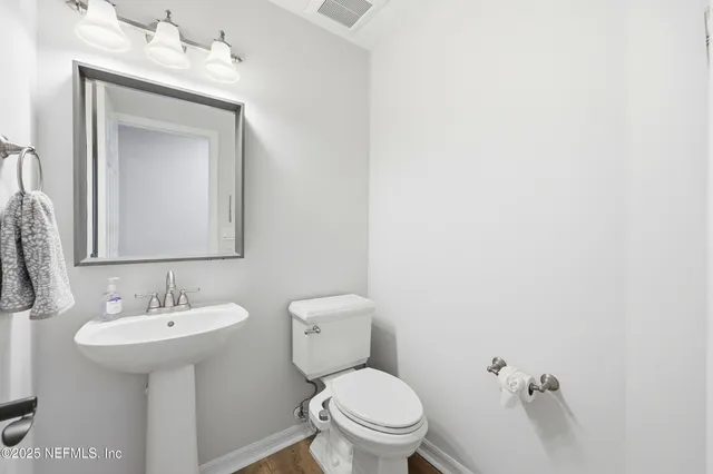 a view of a white house with a big yard and large trees