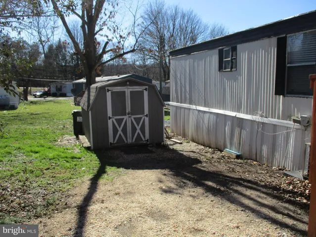 a view of a house with a big yard and large trees