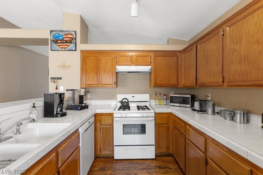 2377 Ramsgate Drive Henderson, NV 89074 - Photo 9 of 25 A well-appointed kitchen features ample wooden cabinetry and durable tile countertops.