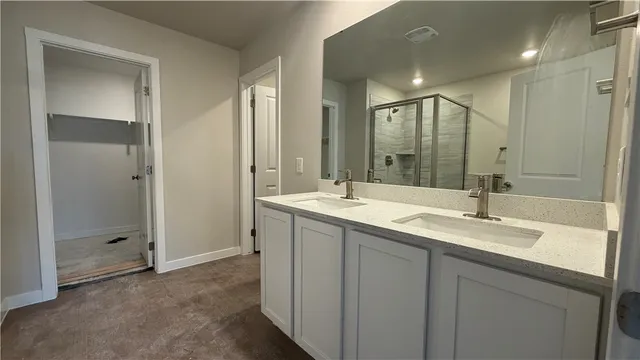 a bathroom with a shower sink vanity and mirror