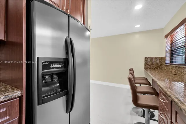 a view of an empty room with chandelier fan and fire place