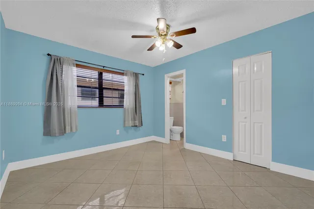 a view of an empty room with a chandelier fan
