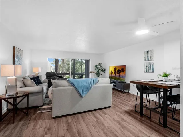 a living room with furniture a flat screen tv and a large window