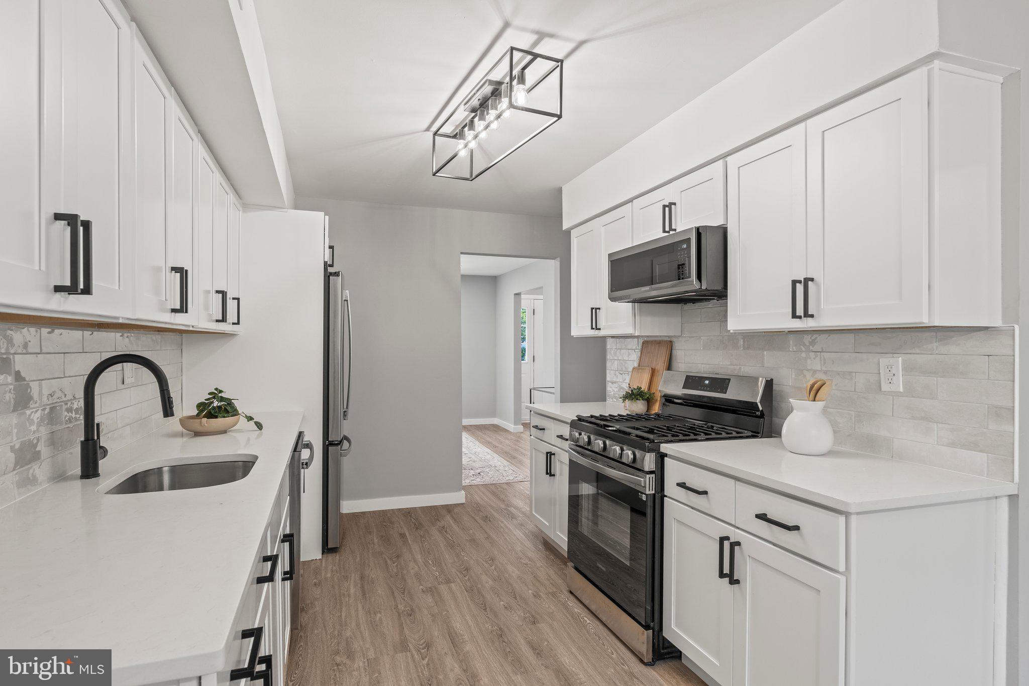 71 Borrelly Boulevard Sewell, NJ 08080 - Photo 10 of 39 a kitchen with stainless steel appliances granite countertop a stove top oven a sink a refrigerator with wooden floor and cabinets