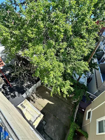a view of a yard with plants and wooden fence