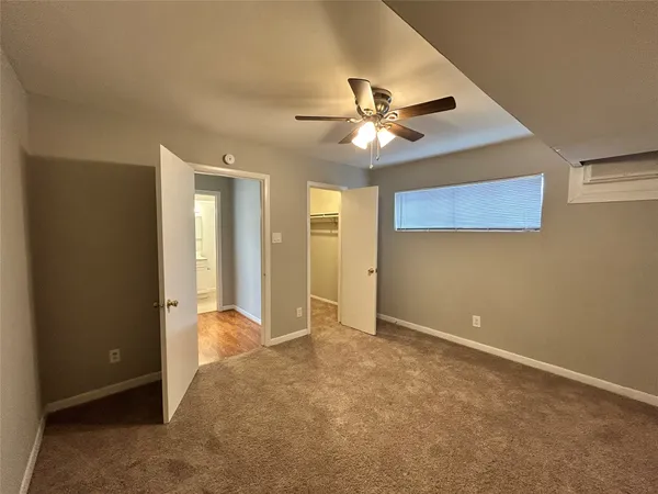an empty room with closet and a ceiling fan