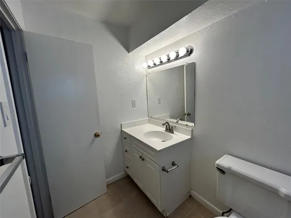 a bathroom with a sink a toilet and mirror