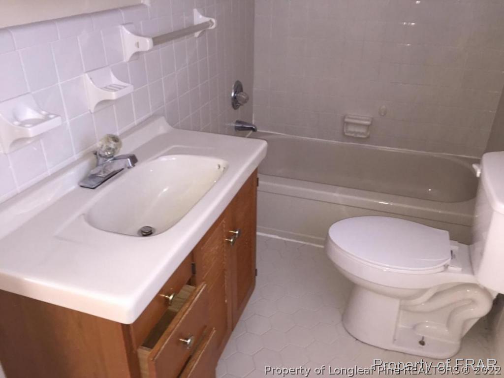 1413 Hibiscus Road Fayetteville, NC 28311 - Photo 7 of 10 a bathroom with a sink a toilet and mirror