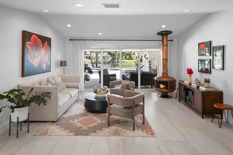 a living room with furniture a large window with table and chairs