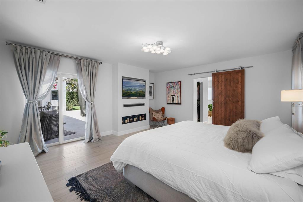 3161 North 36th Street Hollywood, FL 33021 - Photo 37 of 70 a bedroom with a large bed a flat tv screen and a dresser