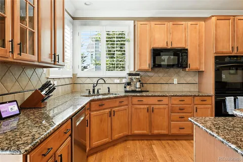 a kitchen with stainless steel appliances granite countertop a sink a stove and cabinets