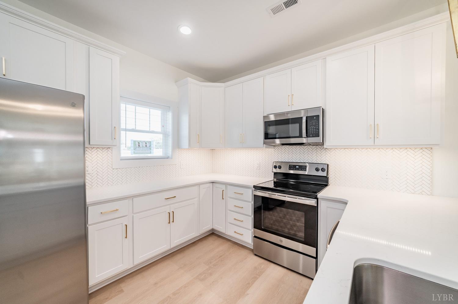 556 Leesville Road, Unit 905 Lynchburg, VA 24502 - Photo 10 of 40 a kitchen with granite countertop white cabinets stainless steel appliances and a window