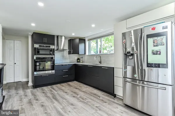 a kitchen with stainless steel appliances granite countertop a refrigerator and a sink