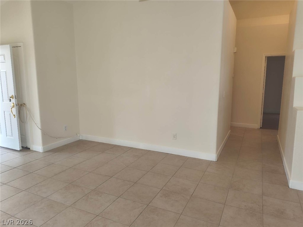 9725 Pima Point Avenue Las Vegas, NV 89147 - Photo 3 of 35 A spacious, naturally illuminated room featuring durable tile flooring and high ceilings, offering versatile living possibilities.