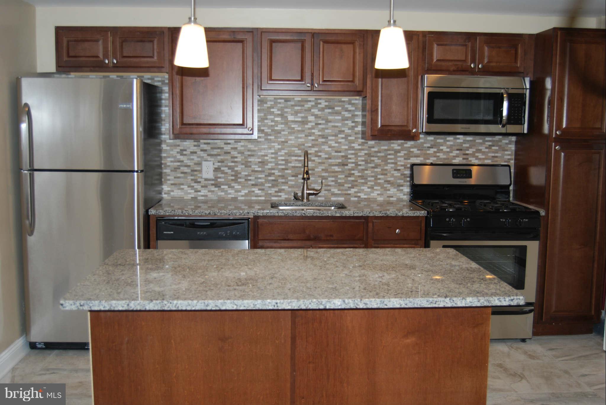 1326 Halstead Road Parkville, MD 21234 - Photo 9 of 30 a kitchen with granite countertop a refrigerator stove and microwave