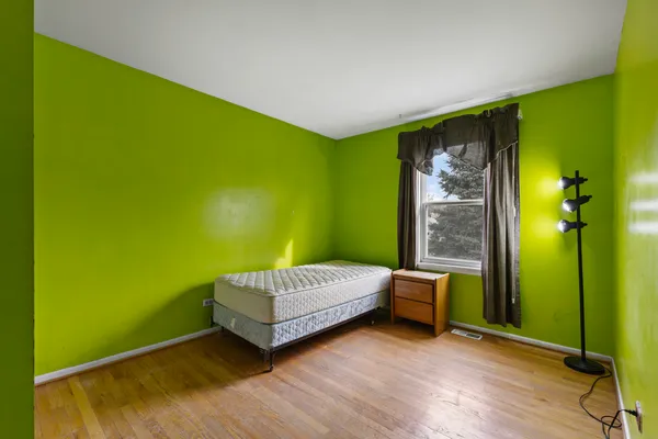a living room with a bed and a dresser