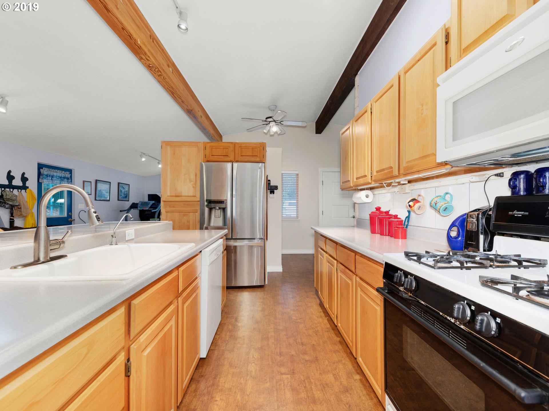 21390 Southwest Farmington Road Beaverton, OR 97007 - Photo 7 of 25 a kitchen with stainless steel appliances granite countertop a sink stove and cabinets