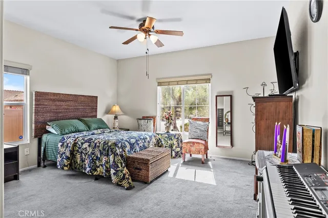 a bedroom with a bed a flat screen tv and a chandelier