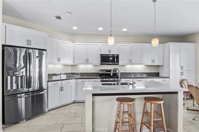 a kitchen with stainless steel appliances granite countertop a stove a sink and a refrigerator