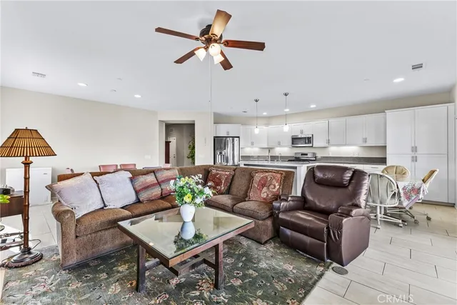 a living room with furniture kitchen view and a potted plant