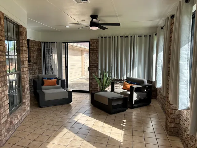 a living room with furniture and large windows