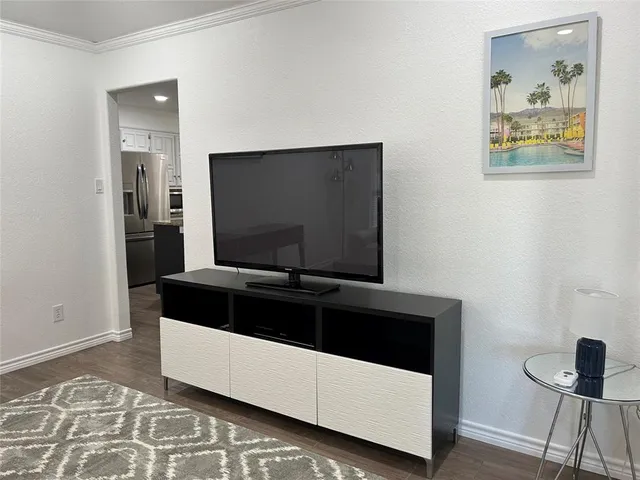 a living room with a bed and a flat screen tv