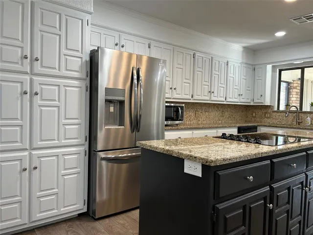 a kitchen with stainless steel appliances granite countertop a refrigerator sink and cabinets