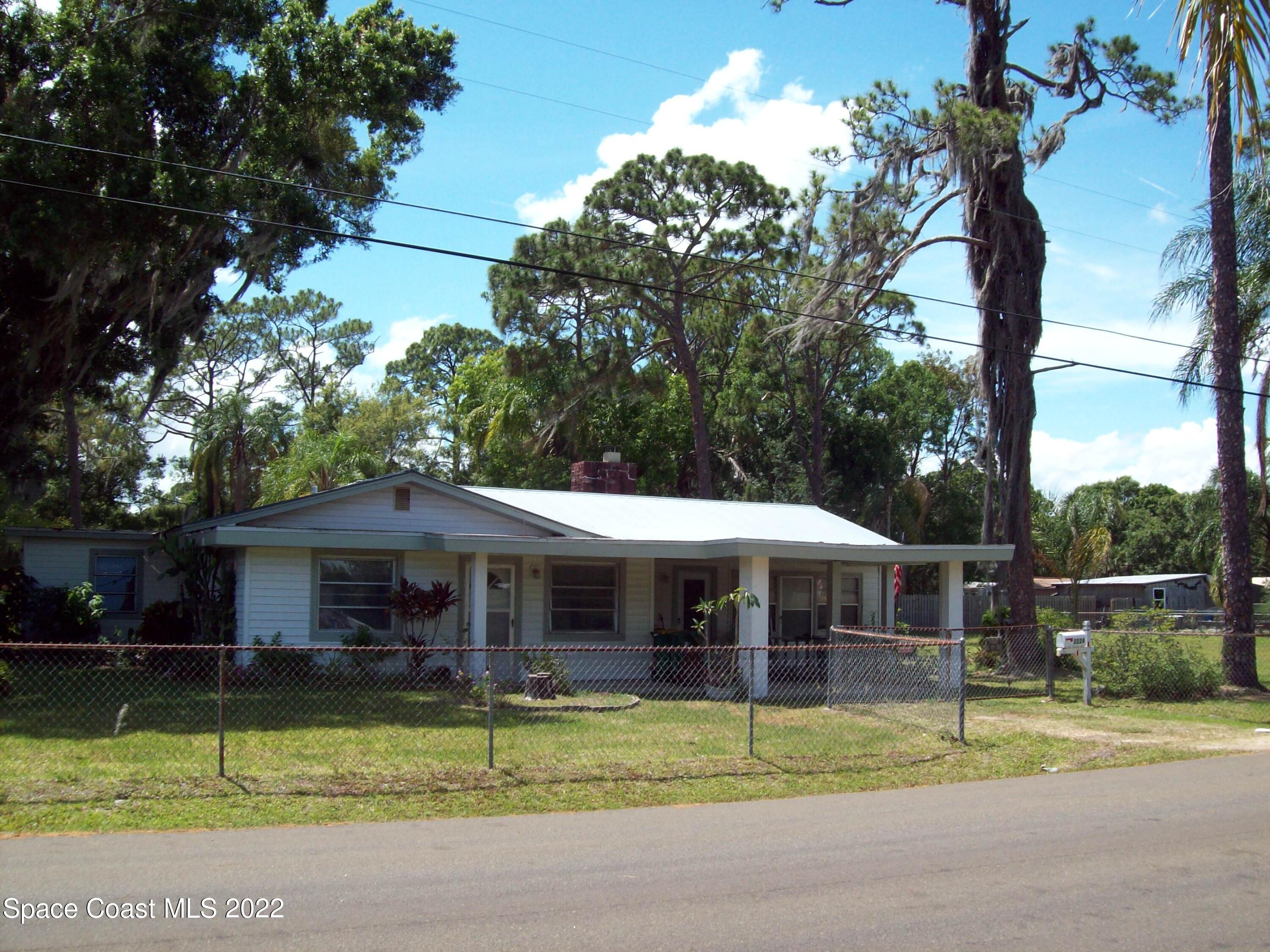 2224 Iowa Street Melbourne, FL 32904 - Photo 1 of 19 a front view of a house with a yard table and chairs