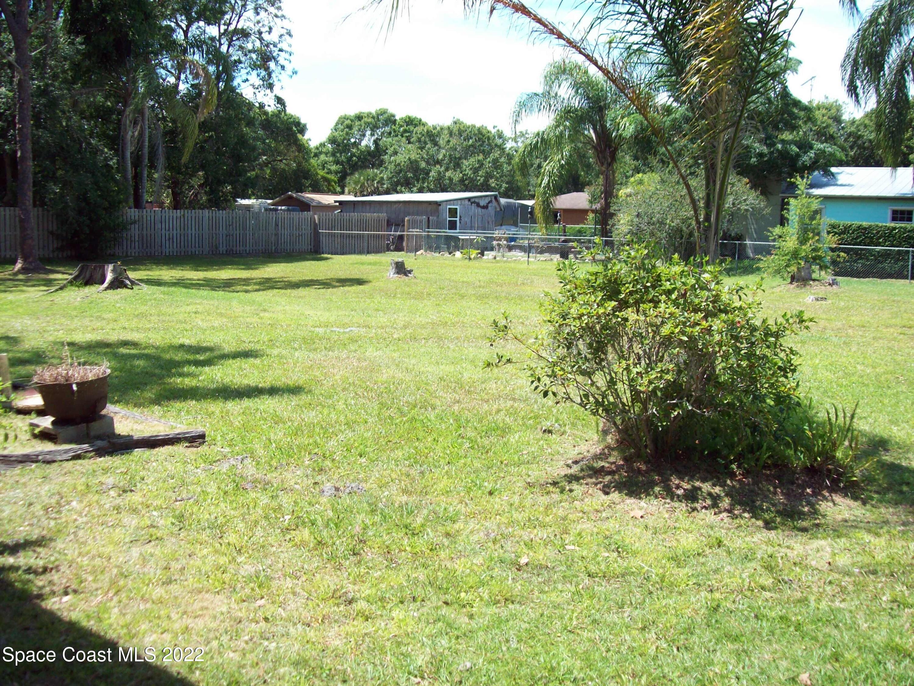 2224 Iowa Street Melbourne, FL 32904 - Photo 19 of 19 a view of a swimming pool with a patio and a yard