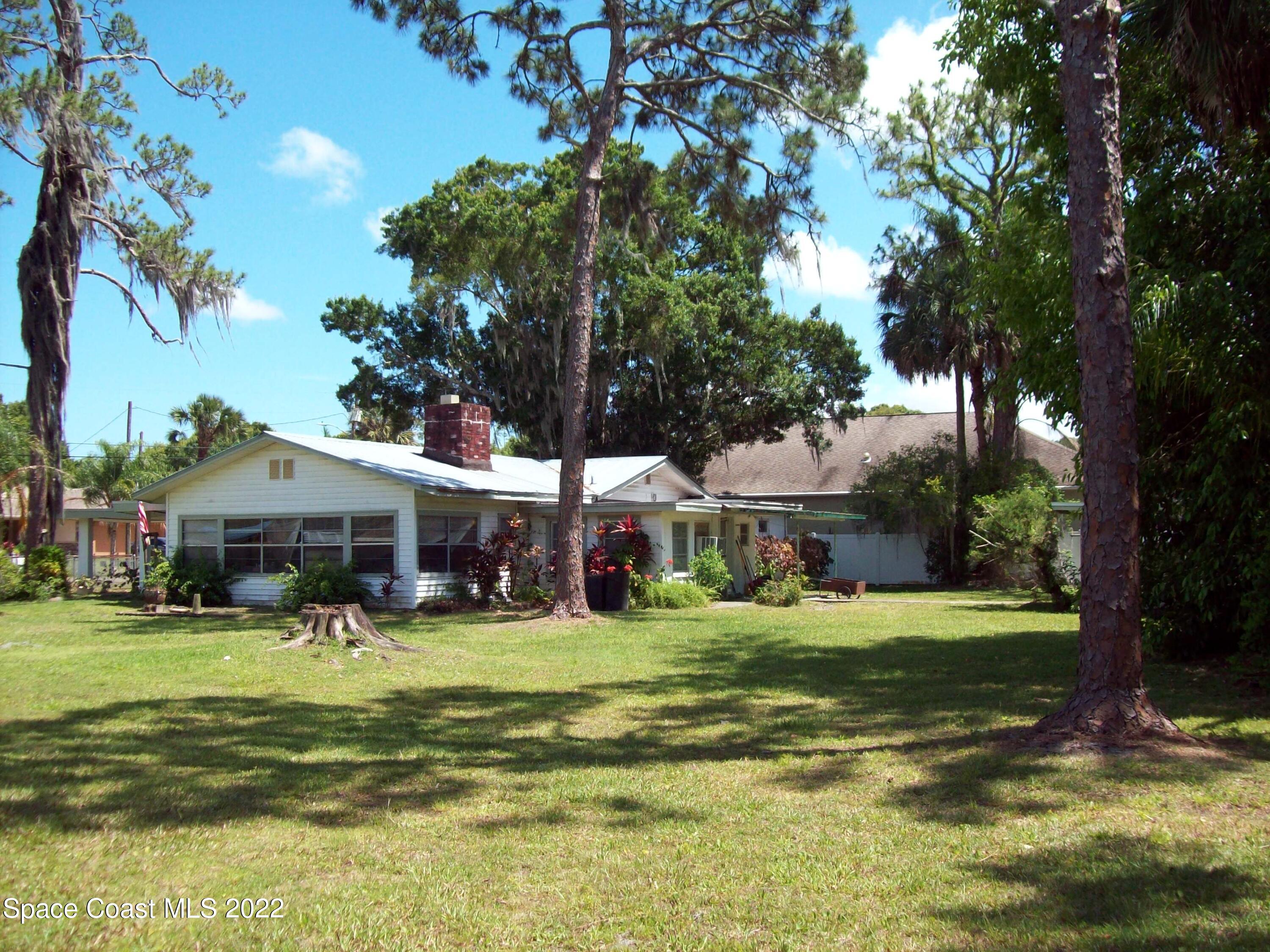 2224 Iowa Street Melbourne, FL 32904 - Photo 4 of 19 a view of a house with a big yard and palm trees
