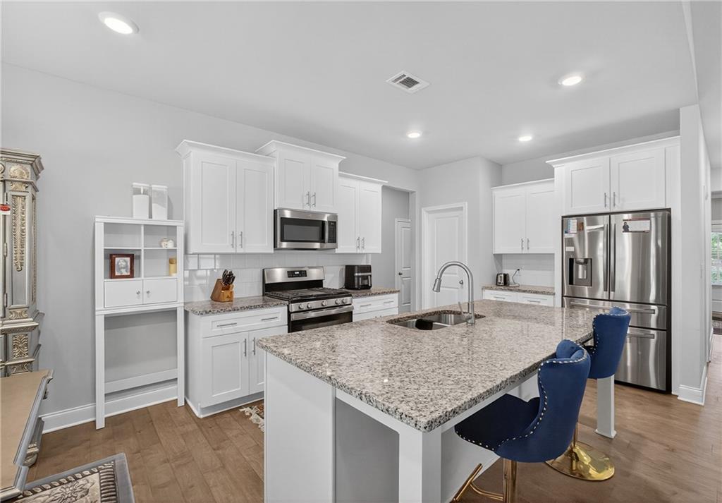 8325 Loch Lomand Lane Winston, GA 30187 - Photo 17 of 31 a kitchen with stainless steel appliances granite countertop a refrigerator a stove a sink a stove a dining table and chairs