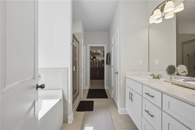 a spacious bathroom with a tub sink and mirror