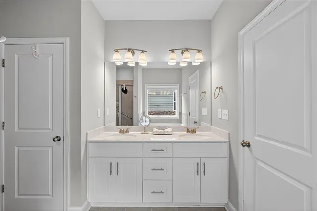 a bathroom with double vanity sinks and a mirror