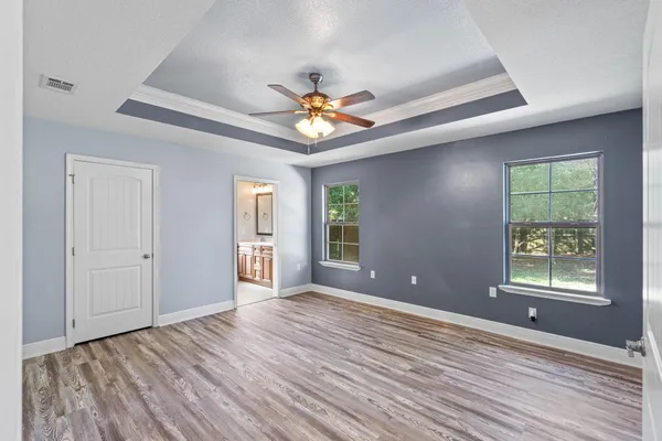 a view of an empty room with window and wooden floor