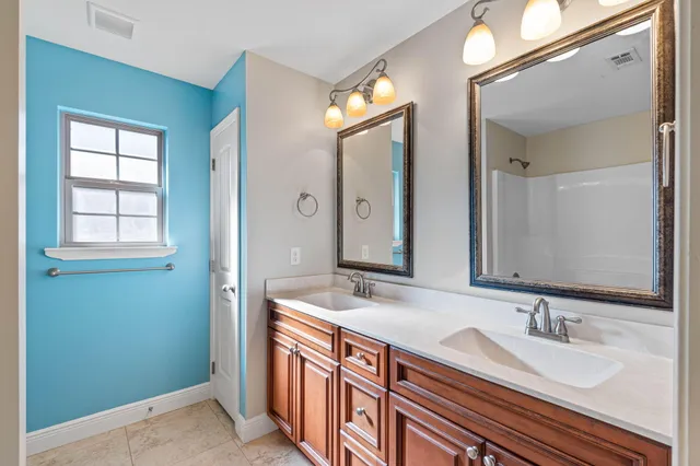 a bathroom with double vanity sink and a mirror