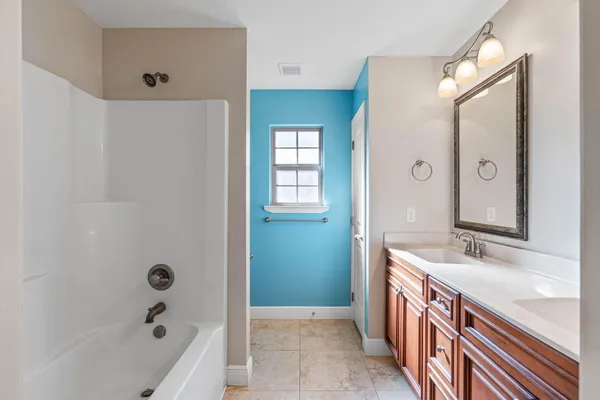 a bathroom with a tub sink and mirror