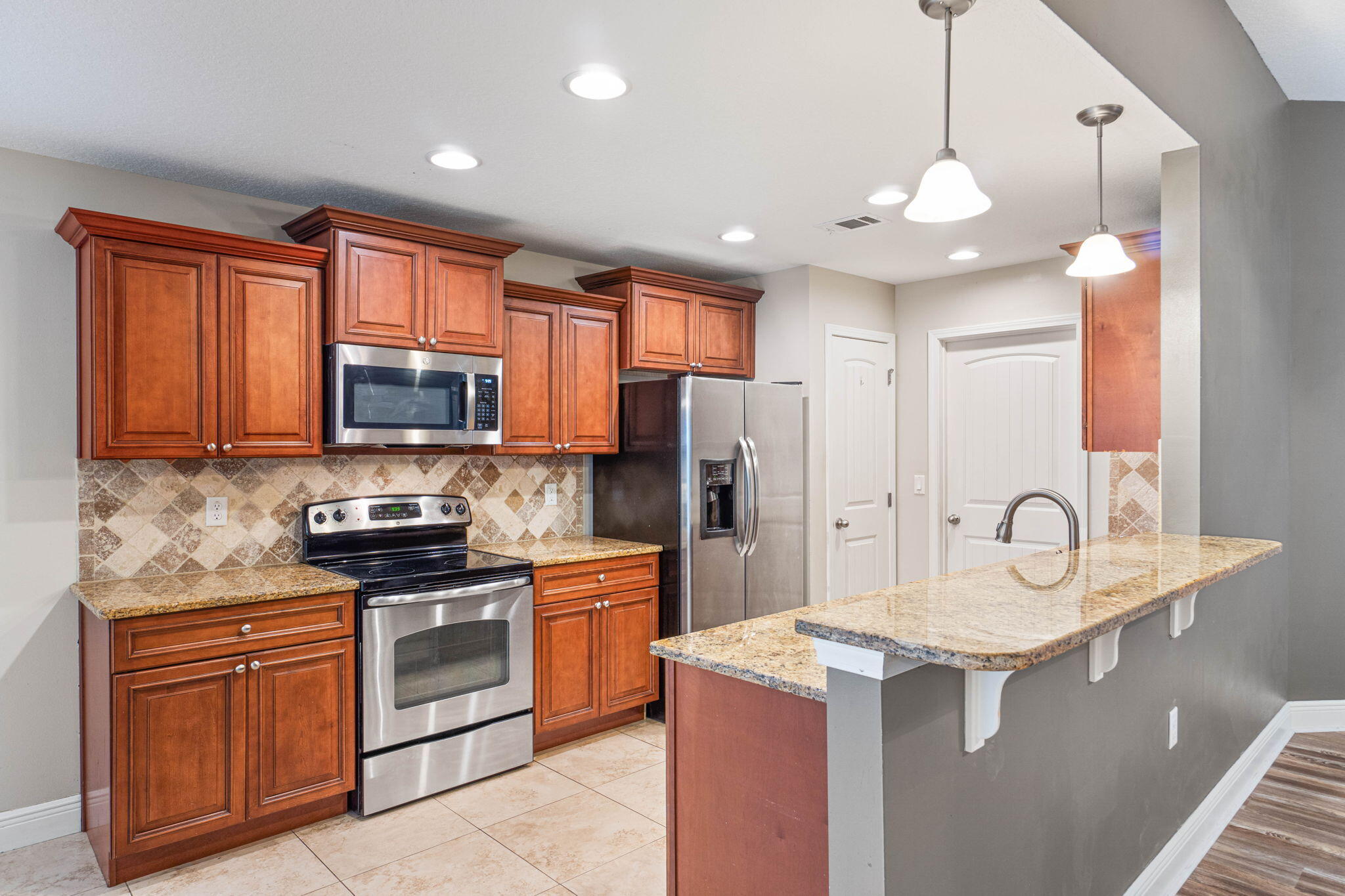 227 January Court Crestview, FL 32539 - Photo 6 of 25 a kitchen with stainless steel appliances granite countertop a sink stove refrigerator and cabinets with wooden floor