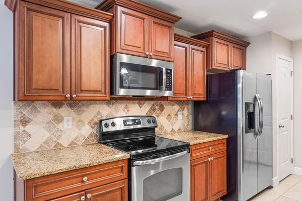 a kitchen with stainless steel appliances granite countertop a refrigerator stove and sink
