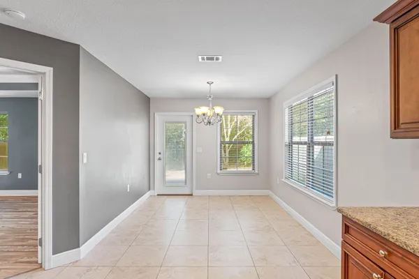 an empty room with windows and chandelier