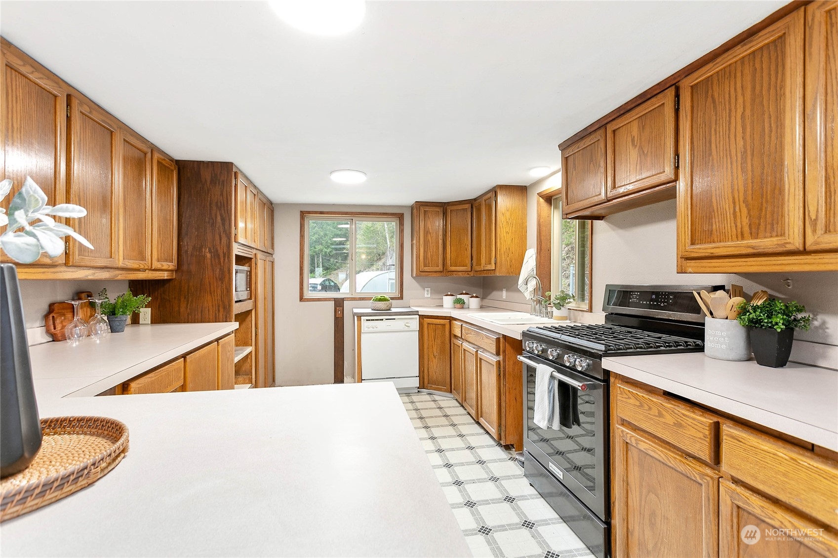 6040 Reese Hill Road Sumas, WA 98295 - Photo 13 of 34 a kitchen with stainless steel appliances granite countertop a refrigerator a stove top oven a sink dishwasher and wooden cabinets with large windows