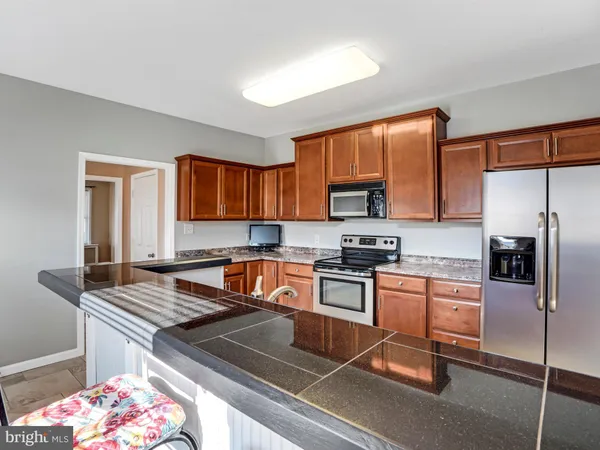 a kitchen with stainless steel appliances granite countertop a stove microwave and sink