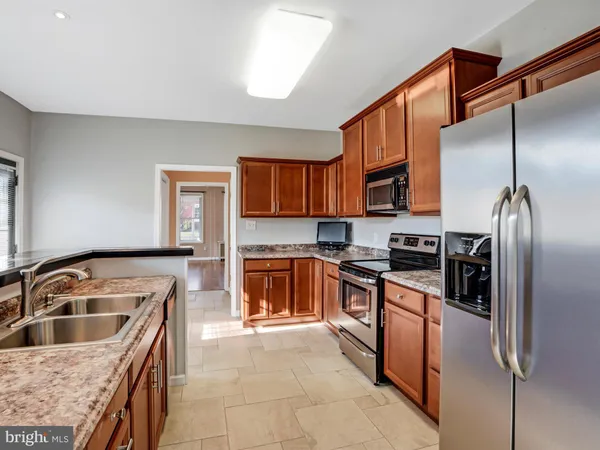 a kitchen with granite countertop a sink and a stove