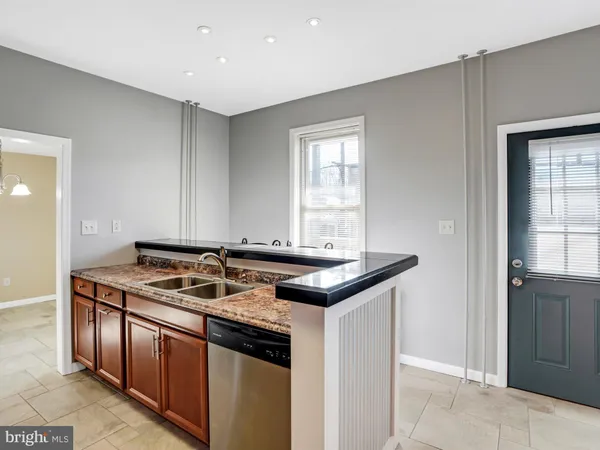 a kitchen with stainless steel appliances granite countertop a sink a stove top oven a counter space and cabinets