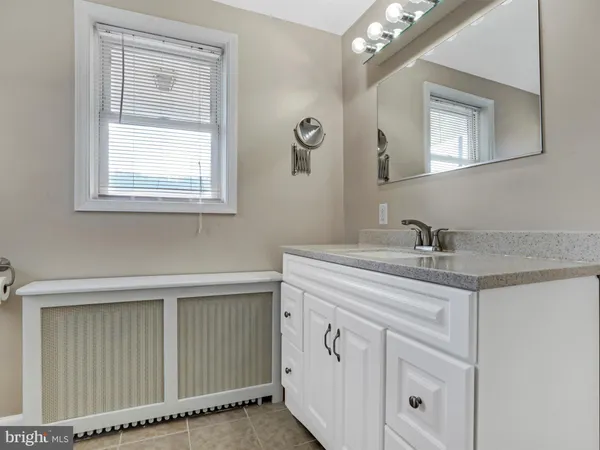 an empty room with a chandelier fan and windows
