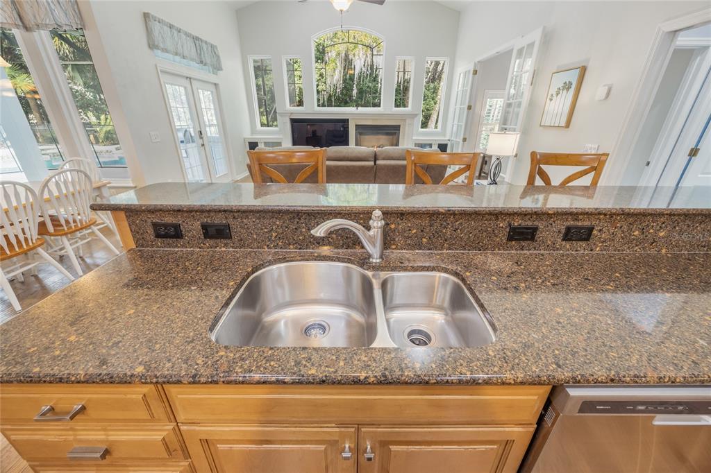 7146 Southwest 35th Avenue Gainesville, FL 32608 - Photo 11 of 83 a kitchen with granite countertop a sink and a wooden floor