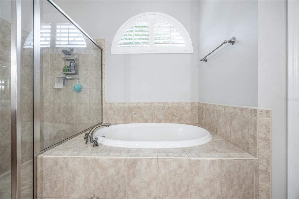 7146 Southwest 35th Avenue Gainesville, FL 32608 - Photo 47 of 83 a bathroom with a granite countertop sink a mirror and a bathtub
